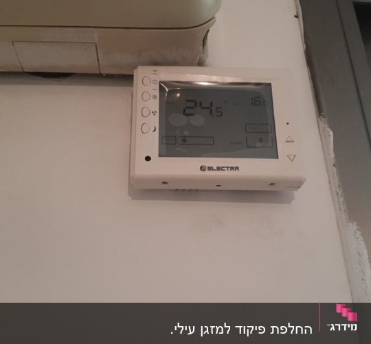 תרמוסטט מזגן על קיר עם תצוגת טמפרטורה